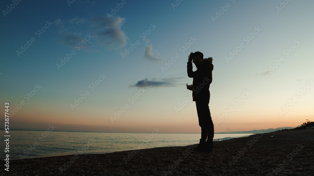 Silhouette of man wearing the virtual reality goggles on the beach Silhouette of man wearing the virtual reality goggles on the beach