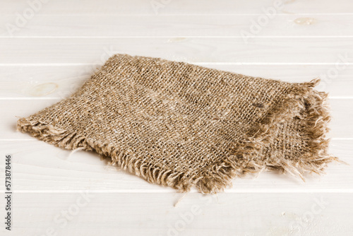 Old burlap fabric napkin, sackcloth on table background. top view with copy space
