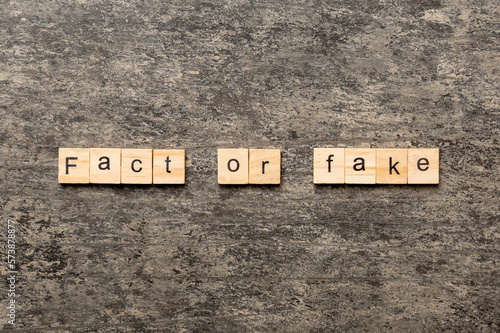 fact or fake word written on wood block. fact or fake text on table, concept