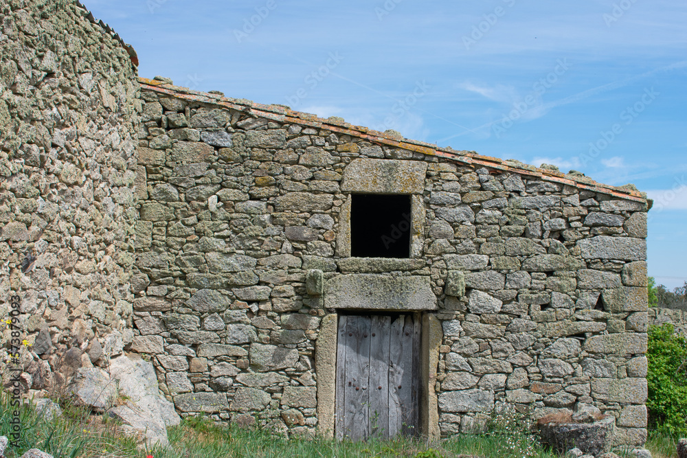 stone house wall with open window and old wooden door