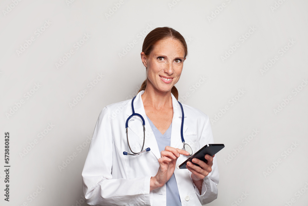 Confident smiling modern mid adult woman doctor medical worker practitioner using smart phone, female portrait Confident smiling modern mid adult woman doctor medical worker practitioner using smart phone, female portrait