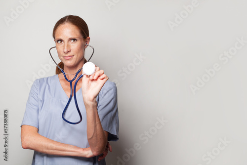 Middle age adult nurse or doctor woman with stethoscope looking at the camera. Positive person.