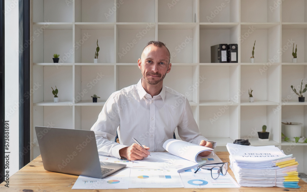 Young business man working at office with laptop and papers on desk Young business man working at office with laptop and papers on desk