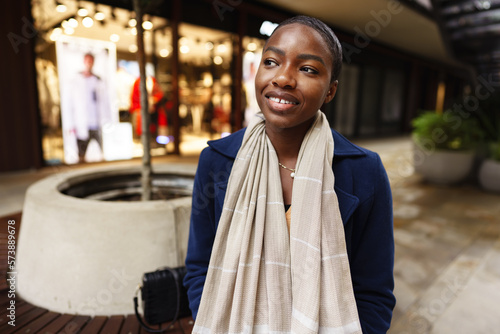 Portrait of smiling young black woman standing in the street