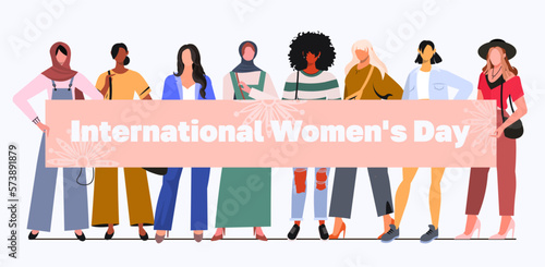 A group of young modern women holding a banner with the inscription International Women's Day. Diverse women standing together for feminism, freedom, independence, empowerment, women rights, equality