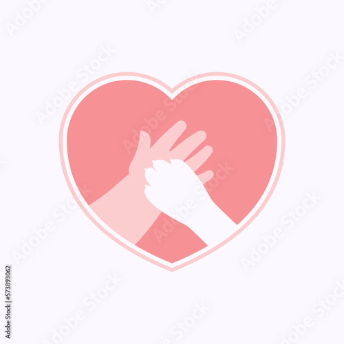 Big paw of dog on hand of kid, in pink heart shaped frame