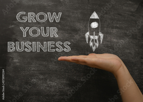 Person points to phrase Grow Your Business on blackboard photo