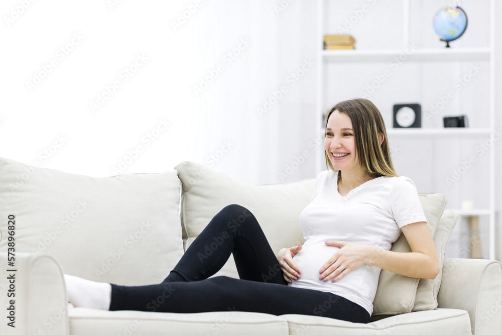 Cheerful young pregnant woman on the sofa. Cheerful young pregnant woman on the sofa.