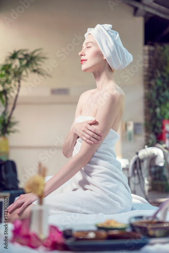 Beautiful young caucasian woman in towel sitting and relaxing and preparing massage in spa salon in hotel.wellness, beauty ,spa and relaxation concept