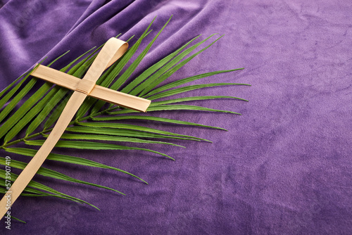 Lent season, Holy week and Good friday concept. Palm leave and cross on purple background photo