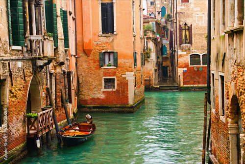 Typical cityscape view of Venice. Narrow canal with emerald water between ancient red brick buildings. Famous touristic place and travel destination in Europe. Winter drizzle day in Venice © evgenij84
