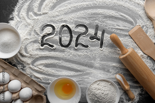 Numbers 2024 on a pastry table along with baking ingredients.