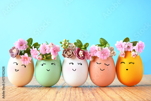 Funny Easter Eggs, hand drawn faces. Easter holiday concept with cute handmade eggs in floral wreath crowns.