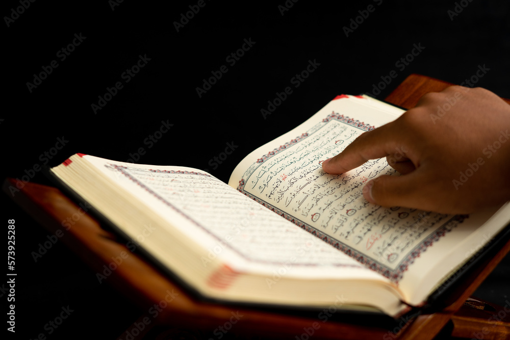 Naklejka premium praying hands on a Quran book