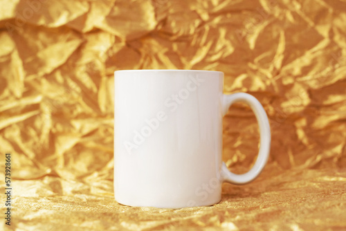 Mockup white blank mug on golden background, copyspace. Template for your design. photo