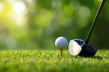 Close-up golf ball on tee with golf drivers at golf course.