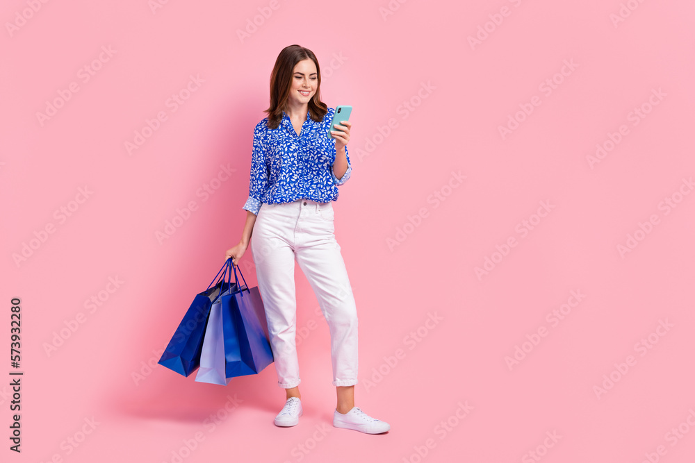 Full length photo of cute shiny woman dressed blue blouse ordering bargains empty space isolated pink color background Full length photo of cute shiny woman dressed blue blouse ordering bargains empty space isolated pink color background
