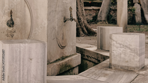 A historical public ablution place in the courtyard of the Ottoman Mosque. Close Up View of Ablution Fountains and stools. Ramadan prayer background