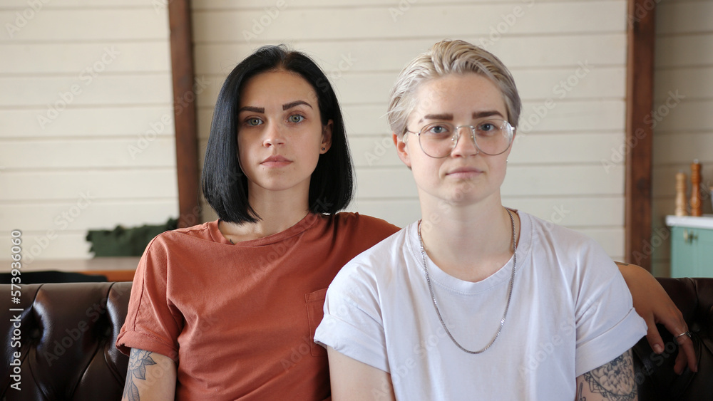 Serious lesbian couple with tattoos poses for camera Serious lesbian couple with tattoos poses for camera