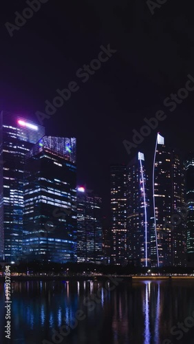 vertical time lapse view of the highrise skyscraper office financial building tower in the central business district area city of Singapore in night time,modern metropolis city photo