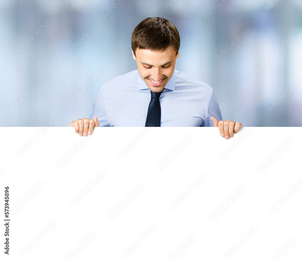Portrait image of business man professional bank manager in confident cloth. Businessman stand behind hang over, look at empty white banner signboard with copy space. Blurred office background Portrait image of business man professional bank manager in confident cloth. Businessman stand behind hang over, look at empty white banner signboard with copy space. Blurred office background