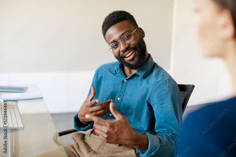 Positive african american businessman explaining new responsibilities to female applicant Positive african american businessman explaining new responsibilities to female applicant