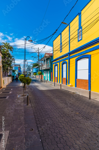 A view up a brightly coloured street in Puerto Plata in the Dominion Republic on a bright sunny day