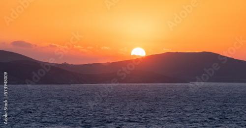 Rocky Island on Mediterranean Sea. Rinia near Mikonos, Greece, Europe. Nature Background. Sunrise Sky