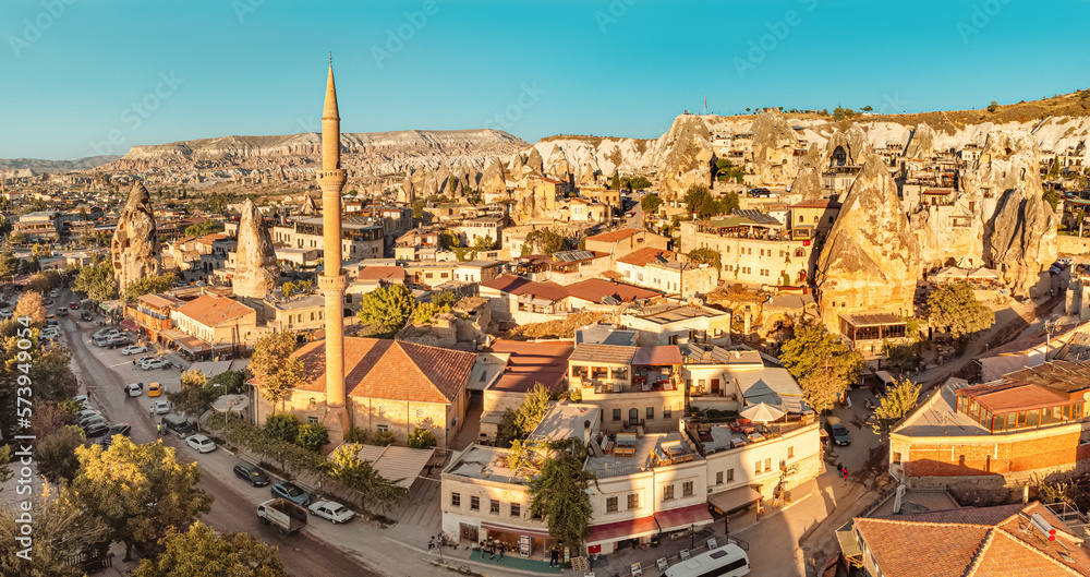 Aerial panoramic view of mosque minaret and Hotels and houses carved into the rocks of soft volcanic tuff in Cappadocia - one of the wonders of Turkey.