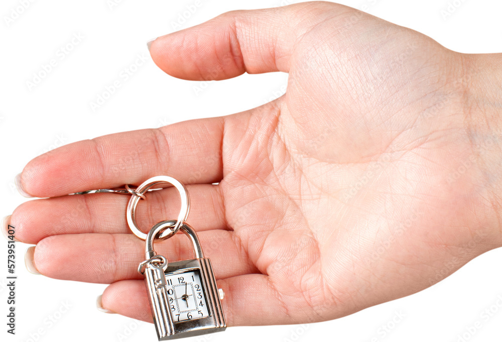 Female hand holding keychain with little clock and key isolated on white background Female hand holding keychain with little clock and key isolated on white background