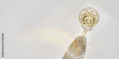 Top view wide banner of white wine in crystal transparent fashion glass with shadow, glare at sunlight, light background and sunbeam, creative summer rest alcohol drink minimal concept