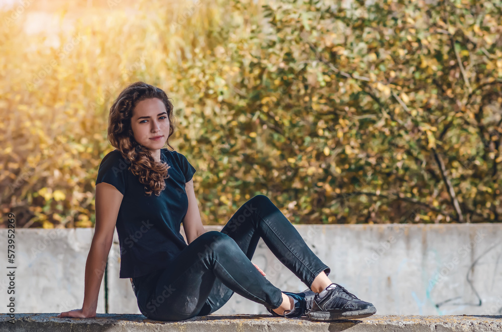 Resting teenage girl sitting on the ground. Dreamy eyes. Sunset background. Resting teenage girl sitting on the ground. Dreamy eyes. Sunset background.