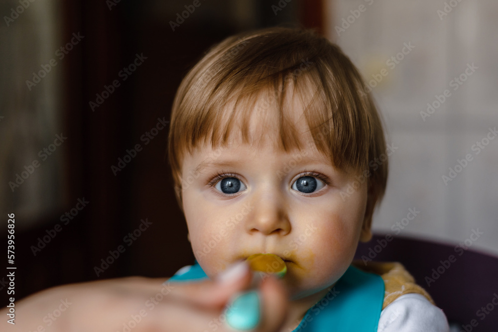 small child sits on a chair and eating with spoon small child sits on a chair and eating with spoon