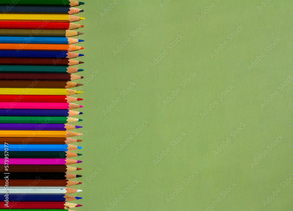 Green background with bright colored pencils Green background with bright colored pencils