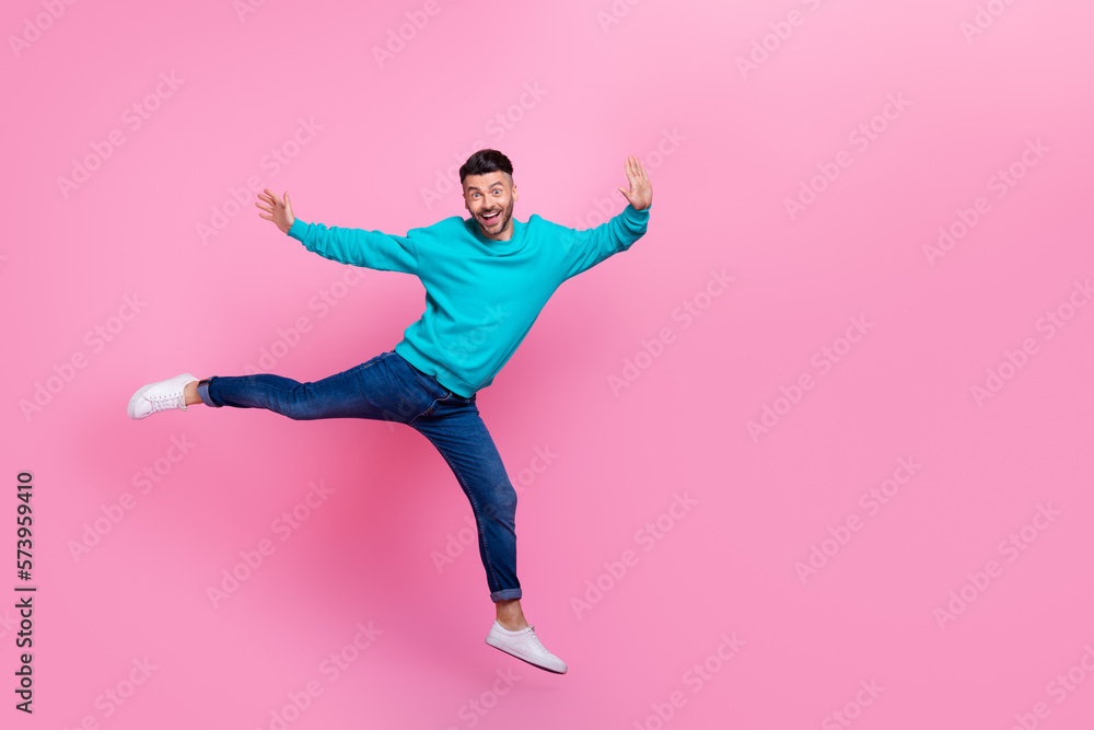 Full length photo of young attractive man jumping carefree excited flying wear trendy blue outfit isolated on pink color background