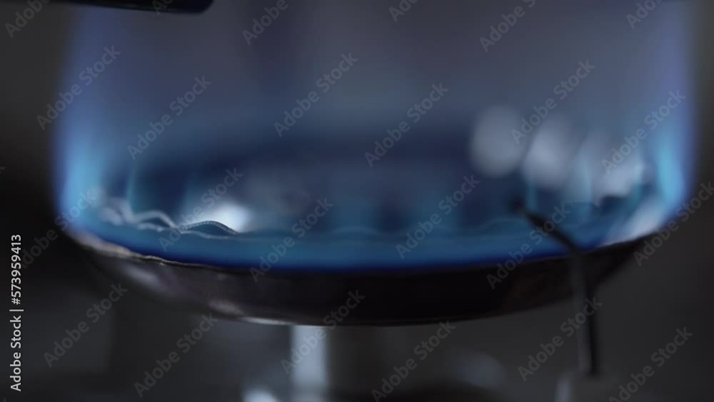 Kitchen gas stove fire inflaming, closeup burning burner flame. Ignite