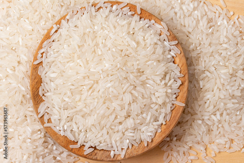 white rice in wooden bowl on wood background