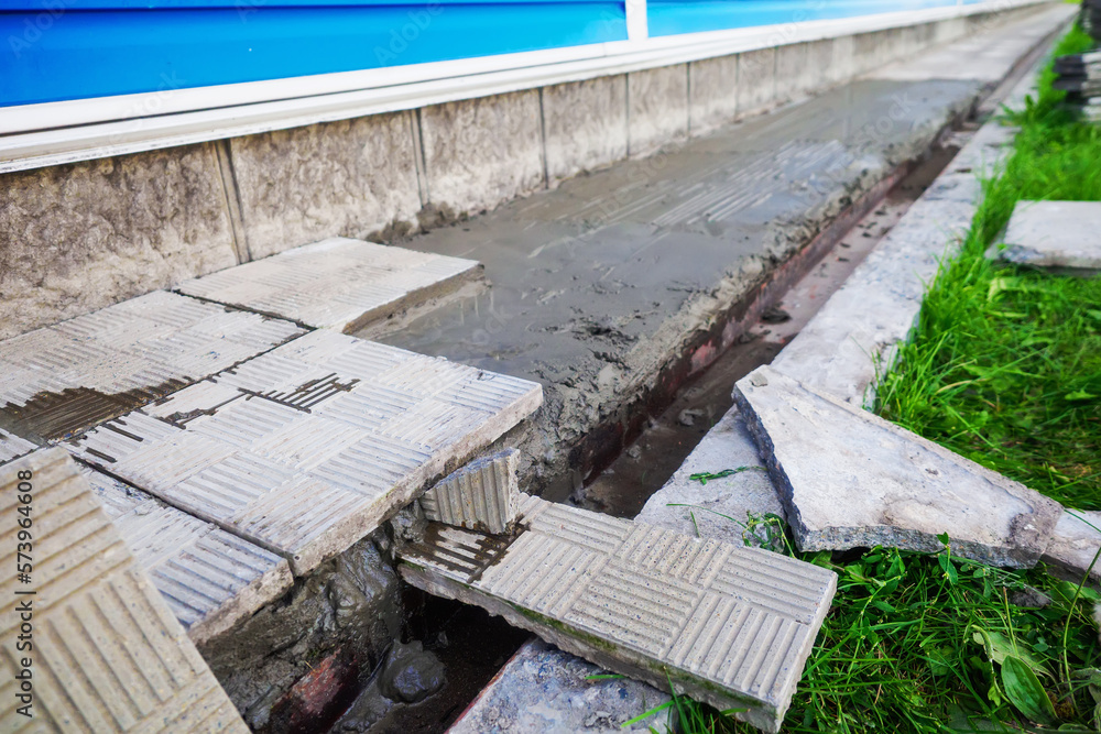 Replacement and repair of the blind area of the building. Laying stone tiles around the house. Construction theme.. Replacement and repair of the blind area of the building. Laying stone tiles around the house. Construction theme..