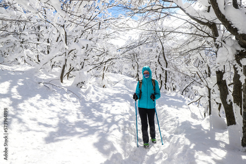 girl hiker among thick snow-covered bushes  amazing, peaceful landscape during a cold winter in the mountains © Jakub
