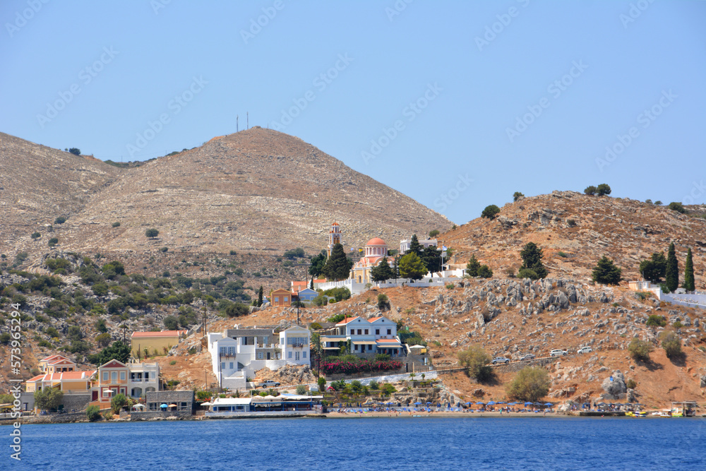 greek island Symi with waterfront, buildings and church isolated on hills  