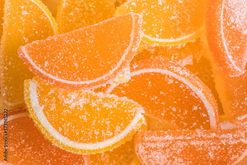 фотографія Decorative Background of yellow and orange marmalade candy in shape of citrus fruits wedges