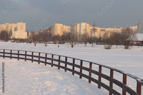 Winter landscape in the city park, snow-covered road and buildings. Houses on the outskirts of Moscow, Russia in winter, Butovo residential area.