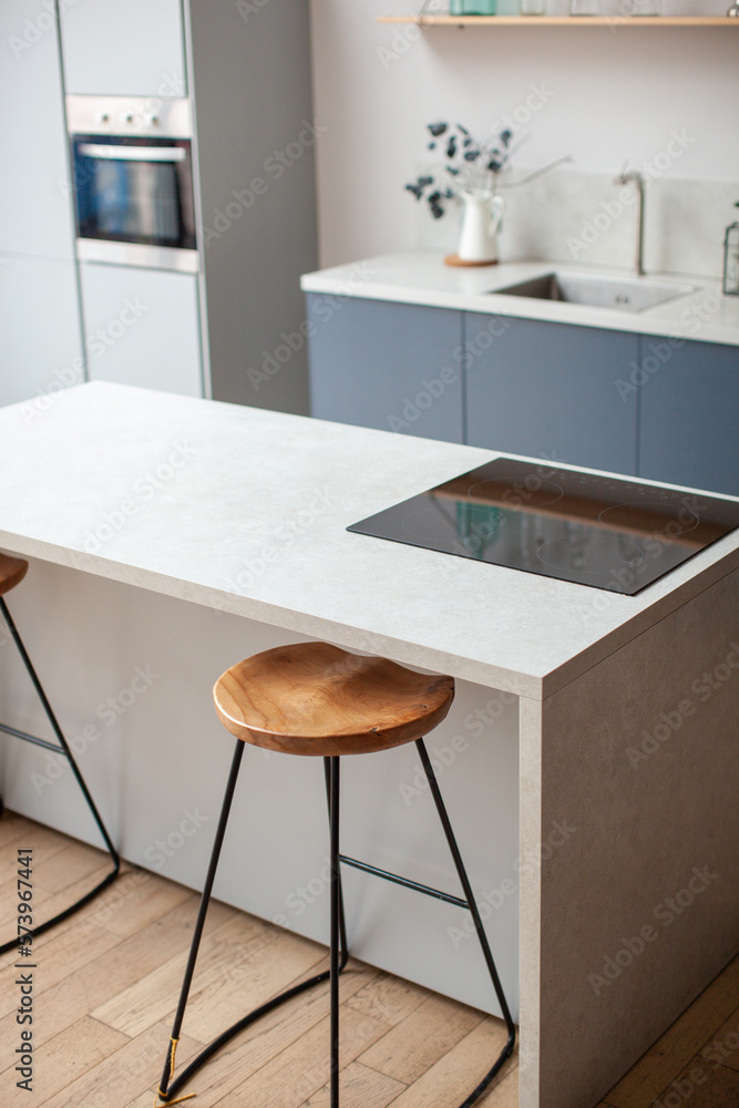 Modern kitchen interior in scandinavian style and gray tones. Kitchen island and bar stool. Close up. 