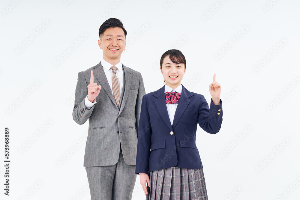 人差し指を立てるポーズをするスーツ姿の男性と女子高生 人差し指を立てるポーズをするスーツ姿の男性と女子高生