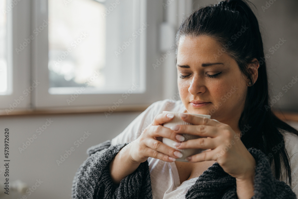 A woman is enjoying the smell of coffee in the morning A woman is enjoying the smell of coffee in the morning