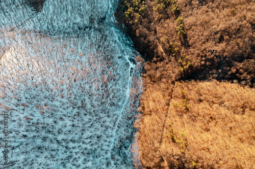 a field, part covered with snow, part not. picture from above photo