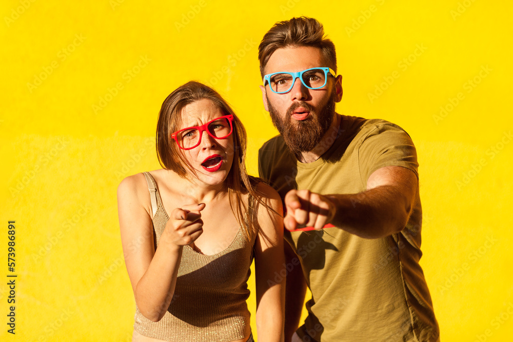 Obraz premium Amazed man and woman standing with shocked face and pointing to camera, having surprised expression.