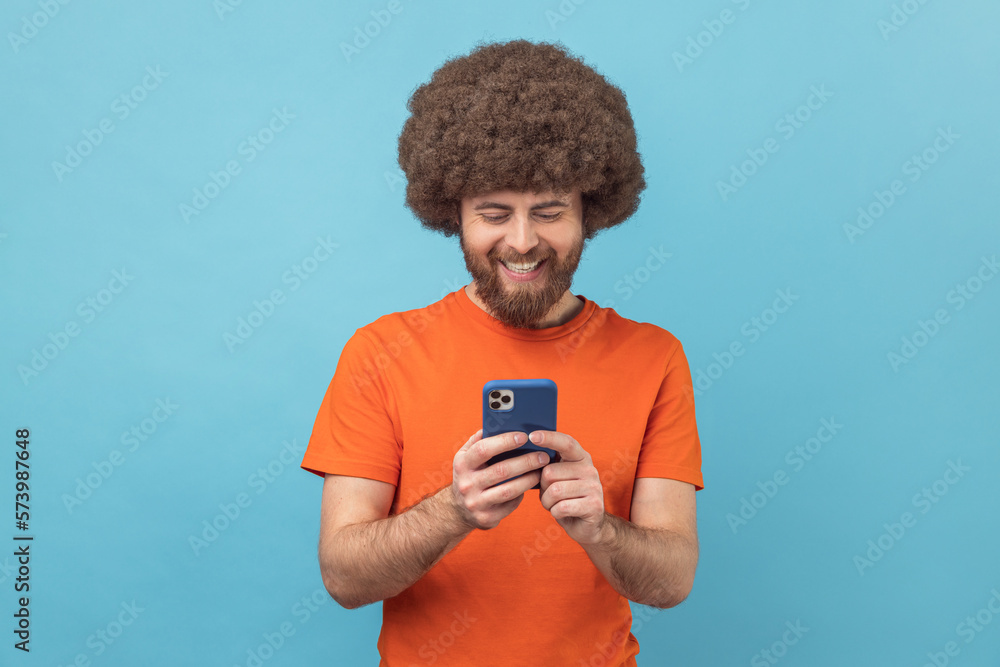 Man blogger standing, using smartphone and watching video with happy smiling face. Man blogger standing, using smartphone and watching video with happy smiling face.