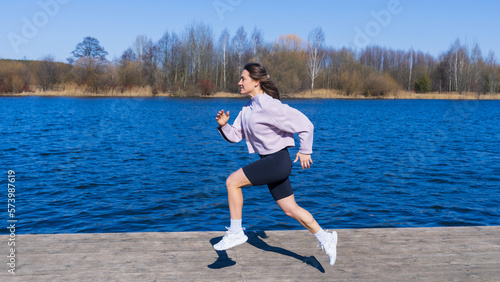 Photos A young woman in a tracksuit runs along promenade