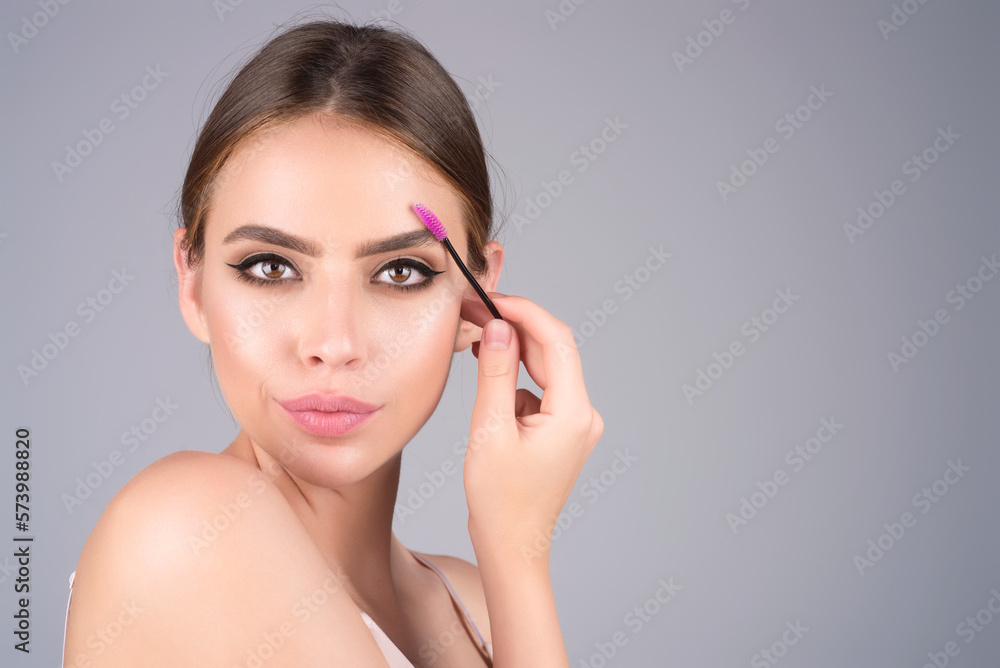 Beautiful woman with dark eyebrows hold eyebrow brush. Eyebrows lamination. Brow beauty procedures. Combs eyebrows with a brus, eyebrow eye line. Beautiful woman with dark eyebrows hold eyebrow brush. Eyebrows lamination. Brow beauty procedures. Combs eyebrows with a brus, eyebrow eye line.